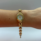 Gold wristwatch on a wrist with a plain background